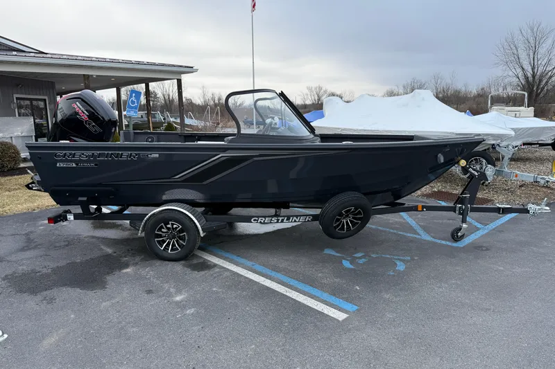The Image of 2026 Crestliner 1750 Hawk boat on trailer in parking lot, overcast sky. - 0