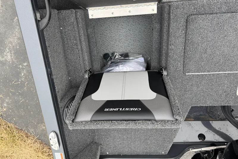 Slide: The Image of 2026 Crestliner 1750 Hawk boat seat with storage compartment, featuring gray and black upholstery. - 16