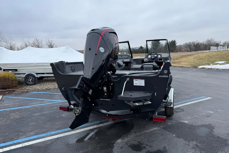 Slide: The Image of 2026 Crestliner 1750 Hawk boat with powerful outboard motor in a parking lot. - 2