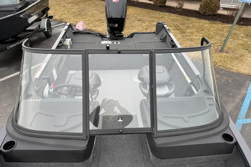 Slide: The Image of 2026 Crestliner 1750 Hawk boat with dual seats and windshield, parked outdoors. - 4