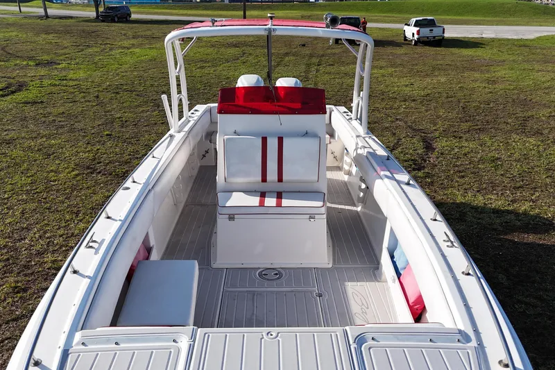 Slide: The Image of 1992 Baja 280 Sportfish boat with red and white seating, parked on grass. - 16