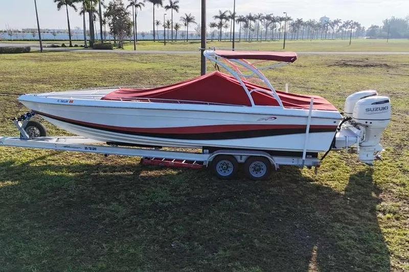 Slide: The Image of 1992 Baja 280 Sportfish boat on trailer with red cover and Suzuki outboard motor. - 5