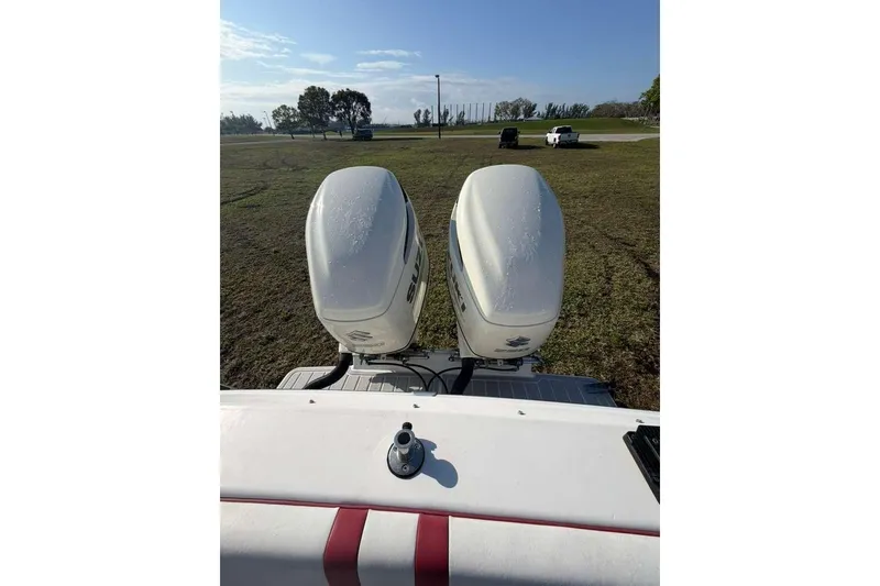 Slide: The Image of 1992 Baja 280 Sportfish boat with dual outboard motors on grassy terrain. - 7