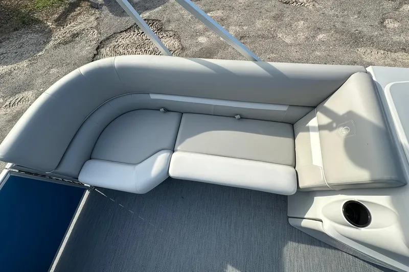 Slide: The Image of 2026 Sweetwater EX 2286 SFLX boat interior with gray cushioned seating and cup holder. - 10