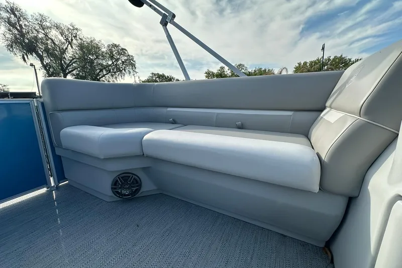 Slide: The Image of Luxurious seating on 2026 Sweetwater EX 2286 SFLX pontoon boat under a partly cloudy sky. - 11