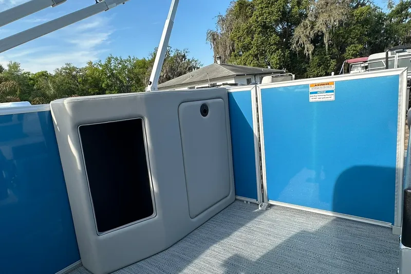 Slide: The Image of 2026 Sweetwater EX 2286 SFLX boat interior with blue paneling and storage compartment. - 21