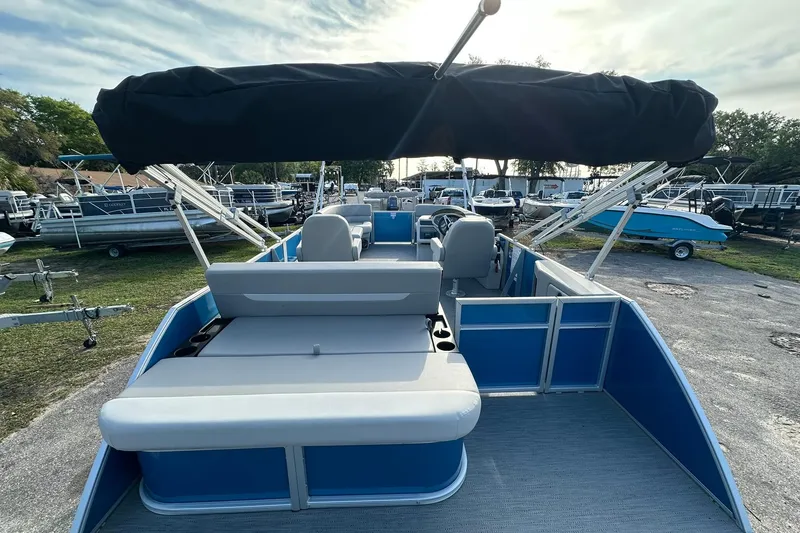 Slide: The Image of 2026 Sweetwater EX 2286 SFLX pontoon boat with canopy, parked outdoors. - 25