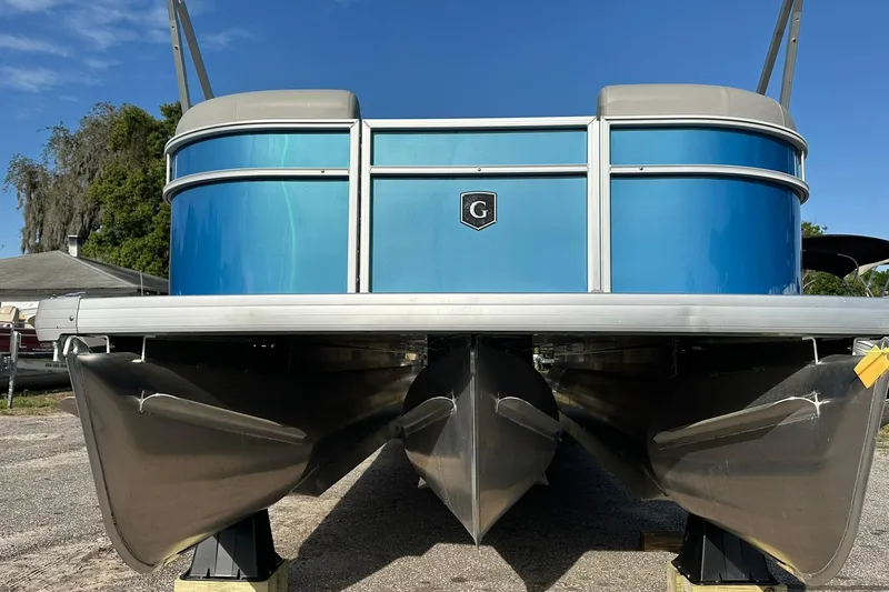 Slide: The Image of 2026 Sweetwater EX 2286 SFLX pontoon boat, blue exterior, parked on land. - 3