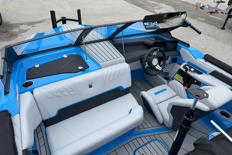 Slide: The Image of 2026 Nautique Ski Nautique boat interior with blue and white seating, modern dashboard, and steering wheel. - 10
