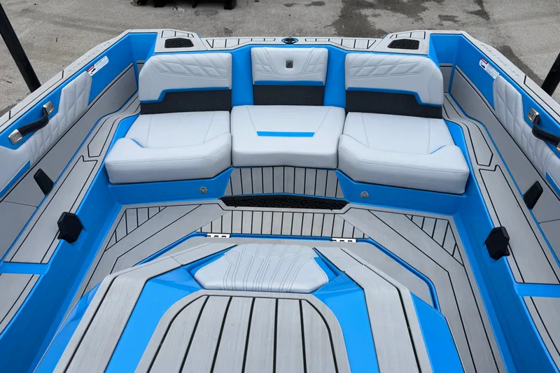 Slide: The Image of 2026 Nautique Ski Nautique boat interior with blue and gray seating and flooring. - 11
