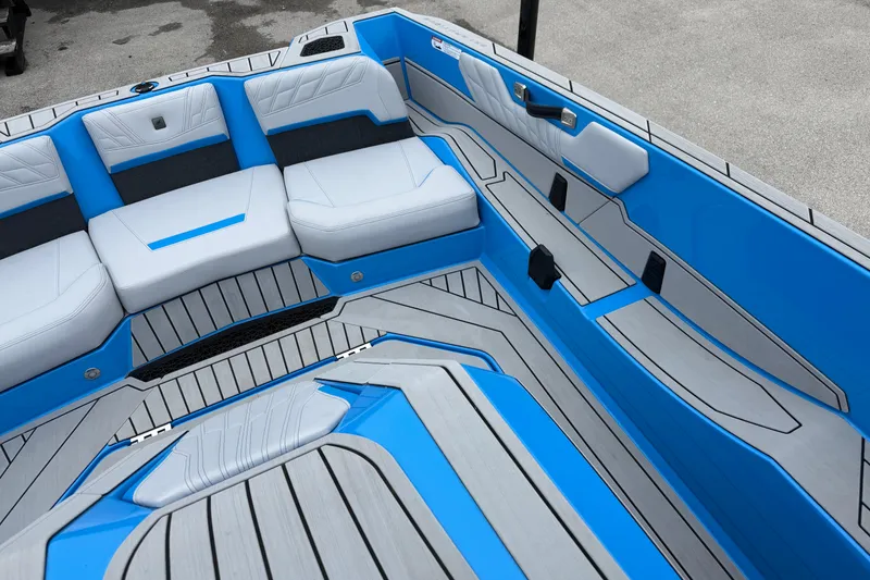 Slide: The Image of 2026 Nautique Ski Nautique boat interior with blue and gray seating and flooring. - 12