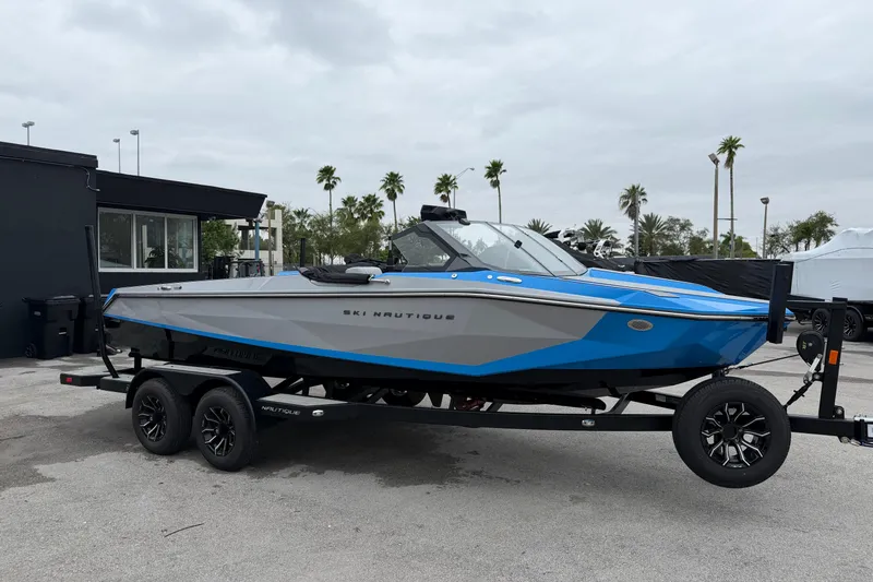 Slide: The Image of 2026 Nautique Ski Nautique boat on trailer, blue and gray design, parked outdoors. - 4