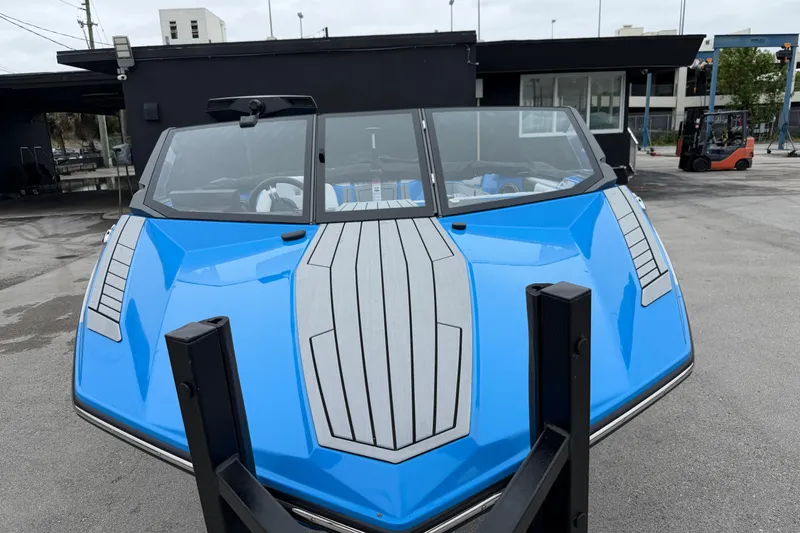 Slide: The Image of 2026 Nautique Ski Nautique boat in vibrant blue, parked outdoors. - 5