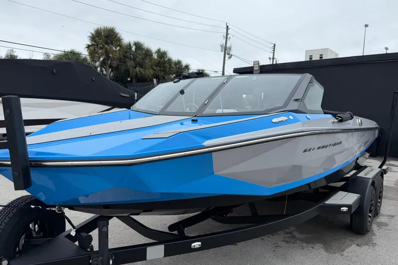 Slide: The Image of 2026 Nautique Ski Nautique boat in blue and gray on a trailer. - 7
