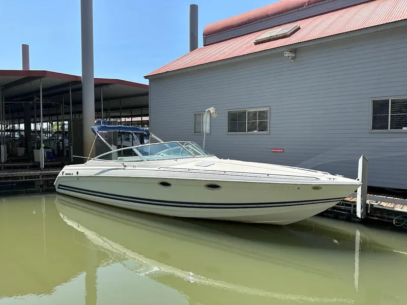The Image of 2000 Formula 330 SS boat docked beside a building, under clear blue sky. - 0