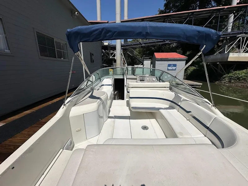 Slide: The Image of 2000 Formula 330 SS boat with blue canopy docked near a building. - 5