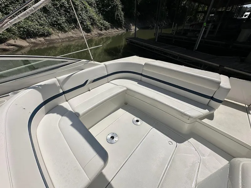 Slide: The Image of 2000 Formula 330 SS boat with white seating and blue accents, docked near lush greenery. - 7