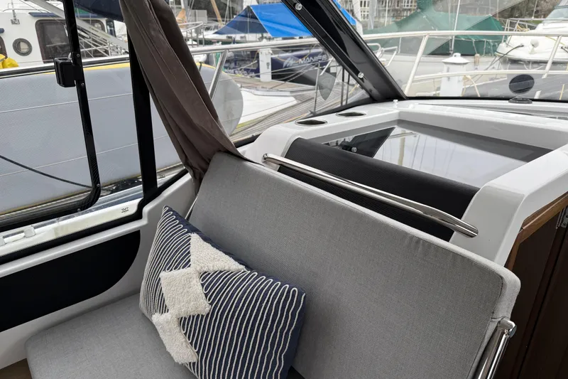 Slide: The Image of Interior of 2020 Jeanneau NC 895 boat with cushioned seating and decorative pillows. - 11