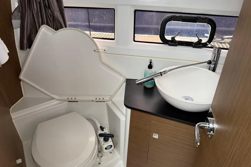 Slide: The Image of 2020 Jeanneau NC 895 boat bathroom with toilet, sink, and window. - 19
