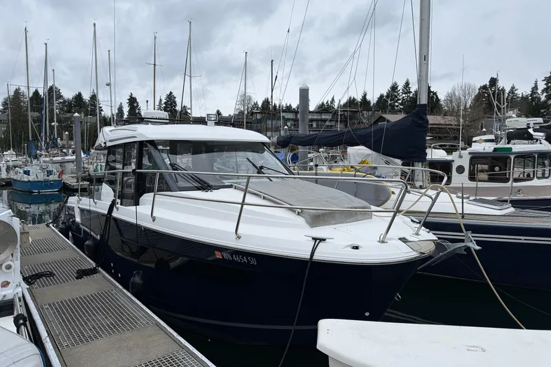 Slide: The Image of 2020 Jeanneau NC 895 boat docked at a marina with other vessels. - 2