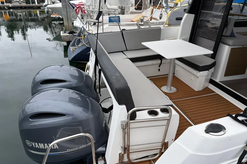 Slide: The Image of 2020 Jeanneau NC 895 boat with Yamaha engines, featuring a cozy seating area and table. - 31