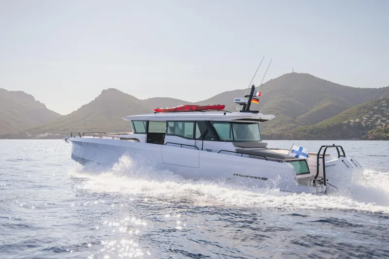 The Image of 2026 Axopar 45 XC Cross Cabin cruising on open water with scenic mountain backdrop. - 0