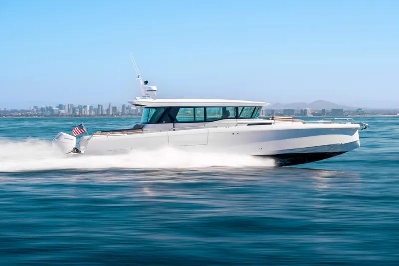 The Image of 2026 Axopar 45 XC Cross Cabin cruising on open water with city skyline in background. - 0