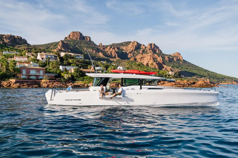Slide: The Image of 2026 Axopar 45 XC Cross Cabin cruising near scenic coastal cliffs and luxury homes. - 4