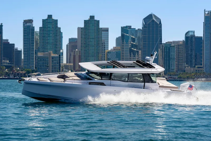 Slide: The Image of 2026 Axopar 45 XC Cross Cabin cruising near city skyline on a sunny day. - 13