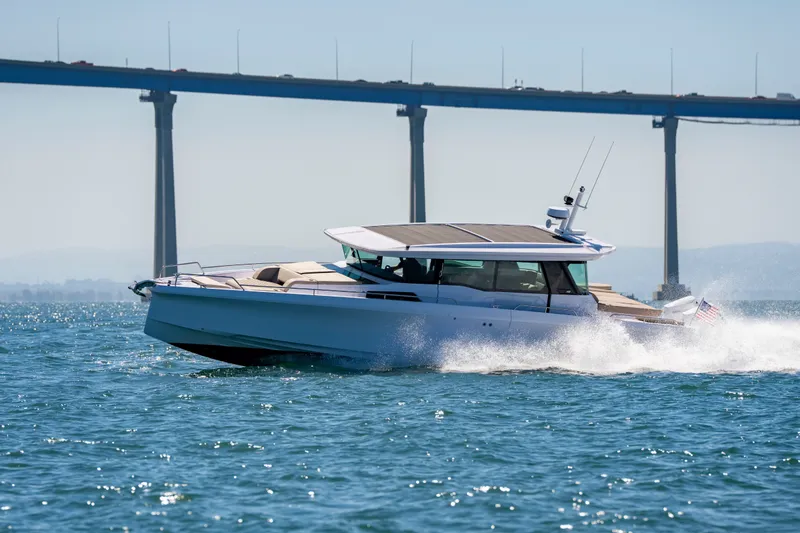 Slide: The Image of 2026 Axopar 45 XC Cross Cabin cruising under a bridge on open water. - 14