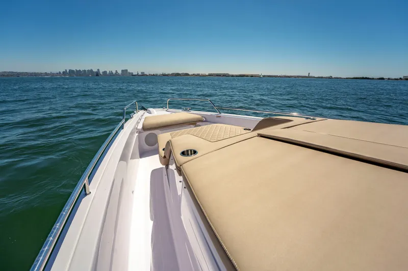 Slide: The Image of 2026 Axopar 45 XC Cross Cabin cruising on open water with city skyline in background. - 22