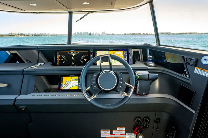 Slide: The Image of Helm of 2026 Axopar 45 XC Cross Cabin with advanced navigation displays and steering wheel. - 27