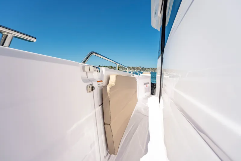 Slide: The Image of 2026 Axopar 45 XC Cross Cabin side deck with sleek design and blue sky backdrop. - 23