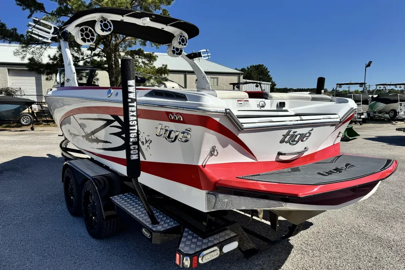 Slide: The Image of 2015 Tigé Z3 boat with red and white design on a trailer. - 5