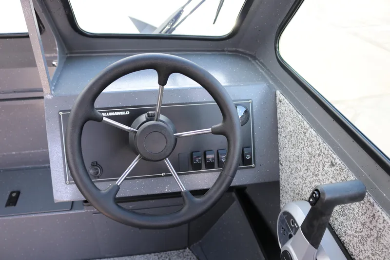Slide: The Image of 2025 Alumaweld Stryker X202 boat dashboard with steering wheel and controls. - 10
