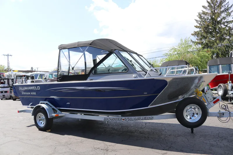 Slide: The Image of 2025 Alumaweld Stryker X202 boat on trailer, blue exterior, parked outdoors. - 3