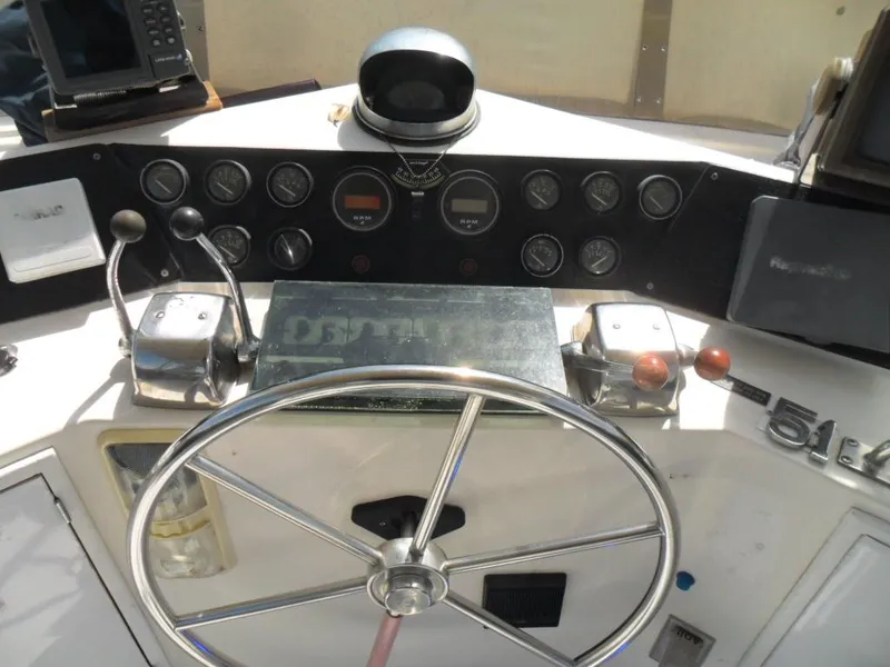 Slide: The Image of 1986 Symbol Yachtfisher helm with steering wheel, gauges, and controls. - 28