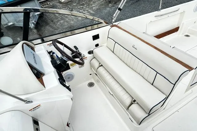 Slide: The Image of 2022 Rossiter R23 Picnic Boat interior with white seating and wooden accents. - 10