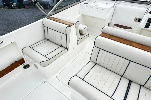 Slide: The Image of 2022 Rossiter R23 Picnic Boat interior with white cushioned seating and wood accents. - 13