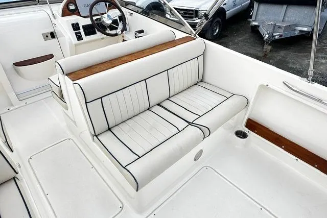 Slide: The Image of 2022 Rossiter R23 Picnic Boat interior with white seating and wood accents. - 11