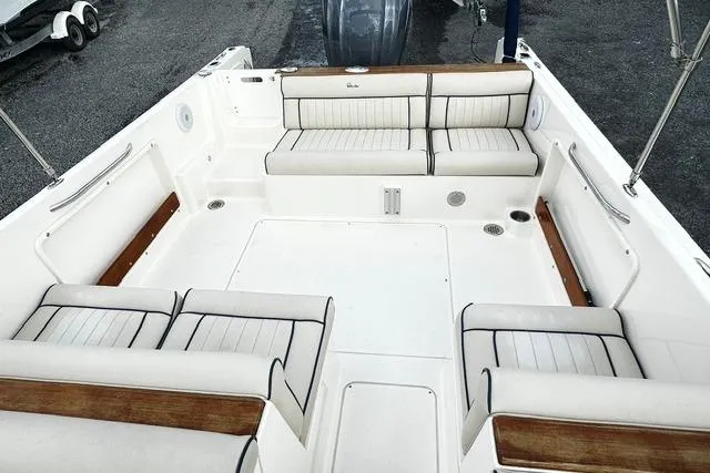Slide: The Image of 2022 Rossiter R23 Picnic Boat interior with white seating and wood accents. - 12