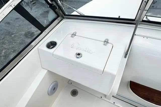Slide: The Image of 2022 Rossiter R23 Picnic Boat interior with storage compartment and cup holder. - 14