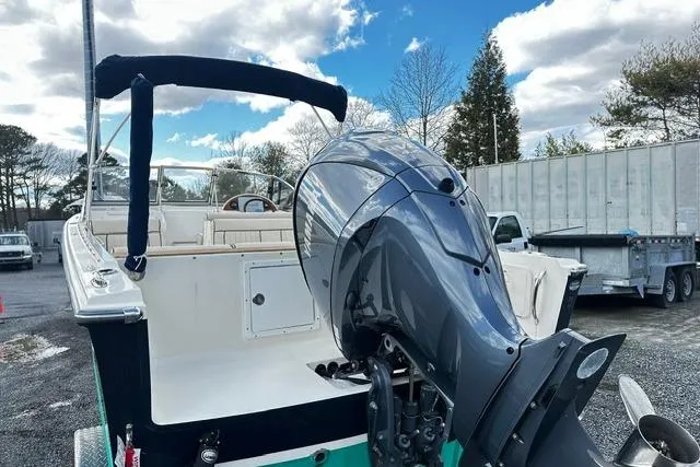 Slide: The Image of 2022 Rossiter R23 Picnic Boat with outboard motor, docked outdoors under cloudy sky. - 4