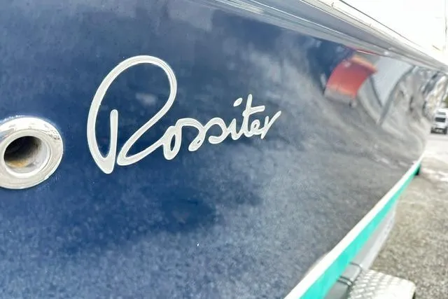 Slide: The Image of 2022 Rossiter R23 Picnic Boat, close-up of logo on sleek blue hull. - 6