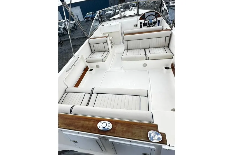 Slide: The Image of 2022 Rossiter R23 Picnic Boat interior with white cushioned seating and wooden accents. - 7