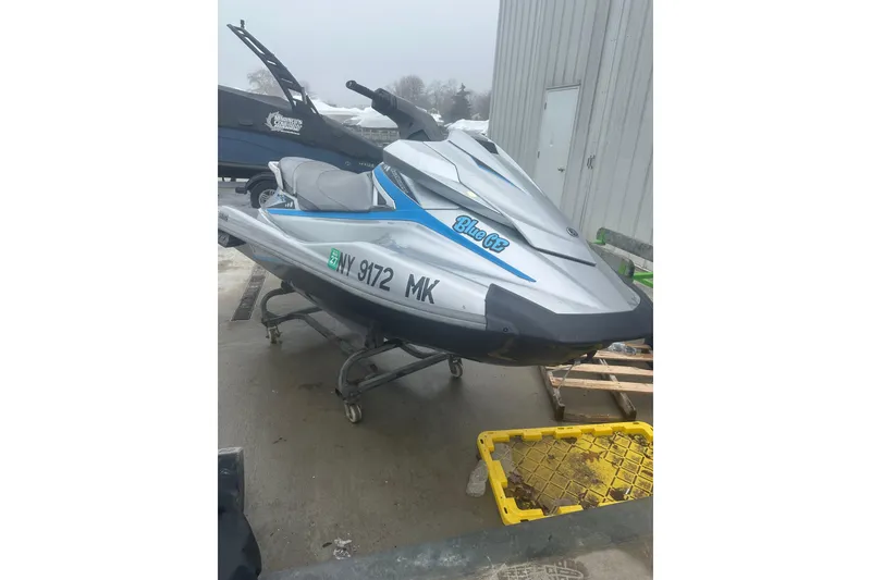 The Image of 2015 Yamaha WaveRunner VX Deluxe jet ski on a stand outside a building. - 1