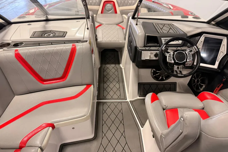 Slide: The Image of 2018 Tigé RZX2 boat interior with gray and red seating, modern dashboard, and steering wheel. - 13