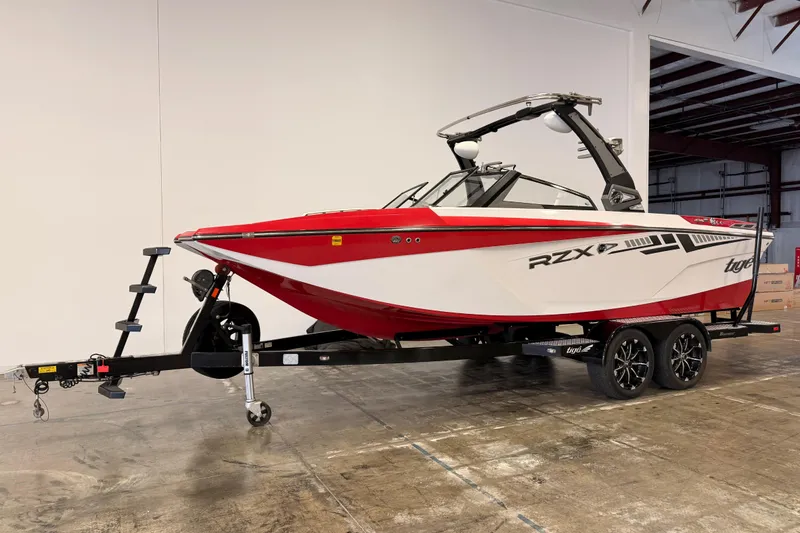 Slide: The Image of 2018 Tigé RZX2 boat in red and white on a trailer in a warehouse. - 3
