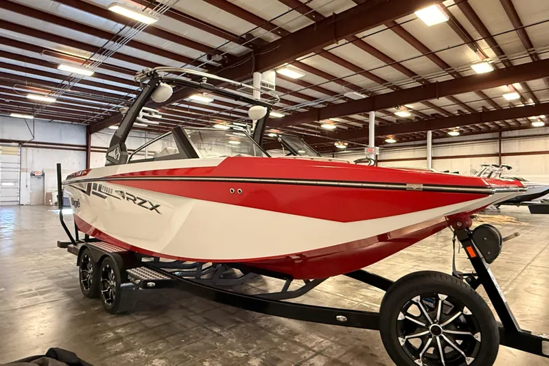 Slide: The Image of 2018 Tigé RZX2 boat in a warehouse, red and white design on trailer. - 4