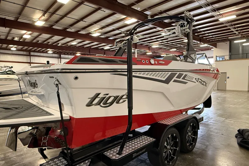 Slide: The Image of 2018 Tigé RZX2 boat in warehouse, red and white design on trailer. - 5